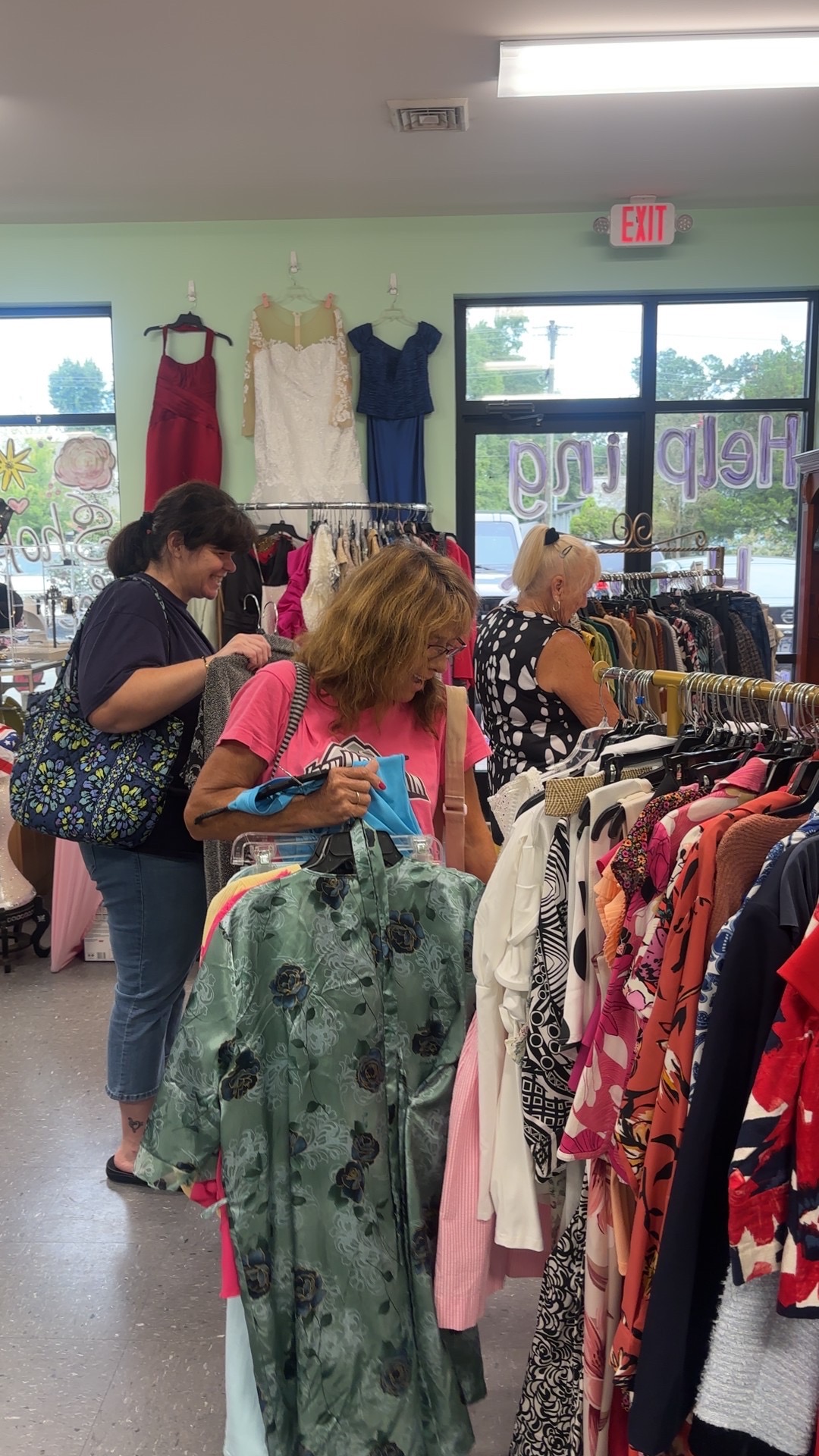 Shoppers browsing racks of clothing at a participating Moriah's Closet
