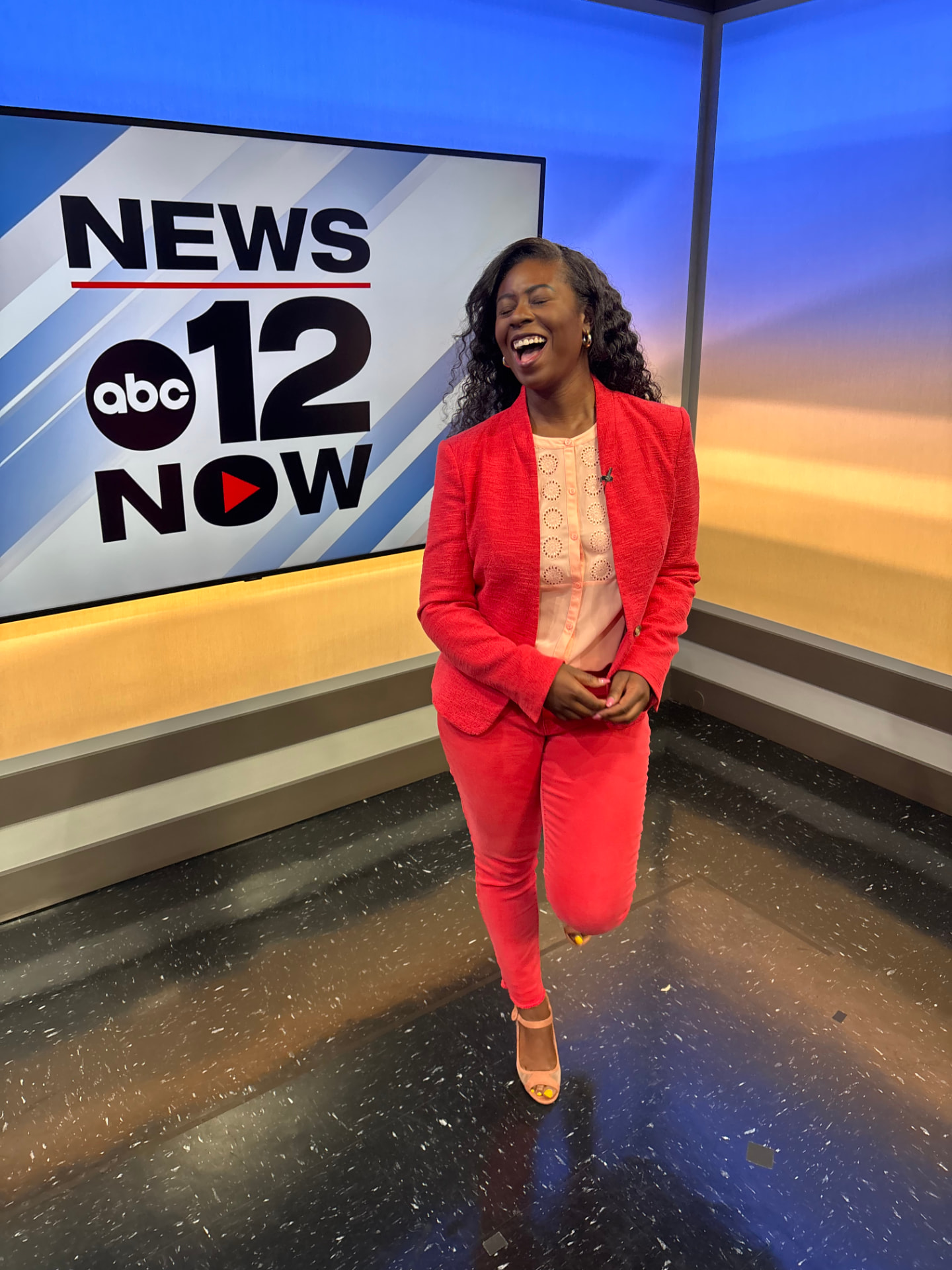 Moriah Davis laughing in a red suit on the ABC 12 News Now set